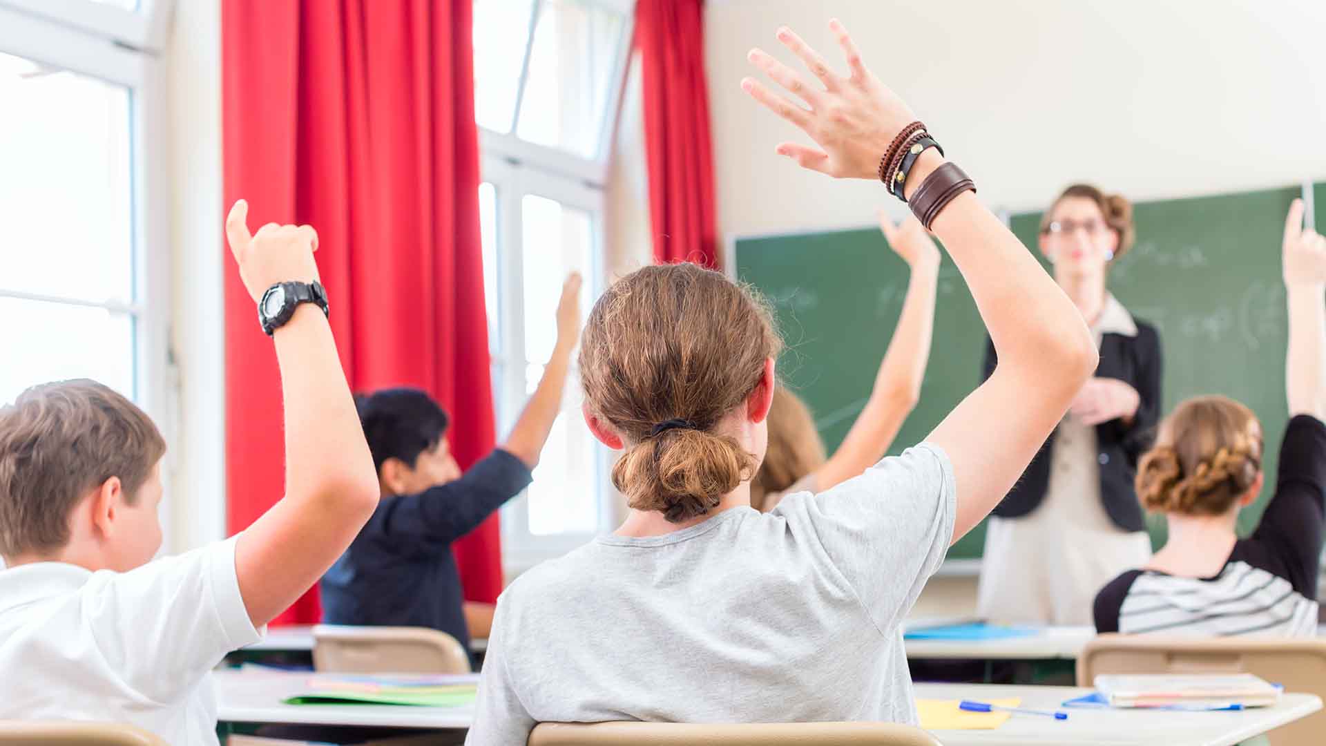 The teacher made the pupils. Фотография класса с учащимися с поднятыми руками. Школьный класс в Австрии. Студент поднимает руку. Младшие школьники поднимают руки.